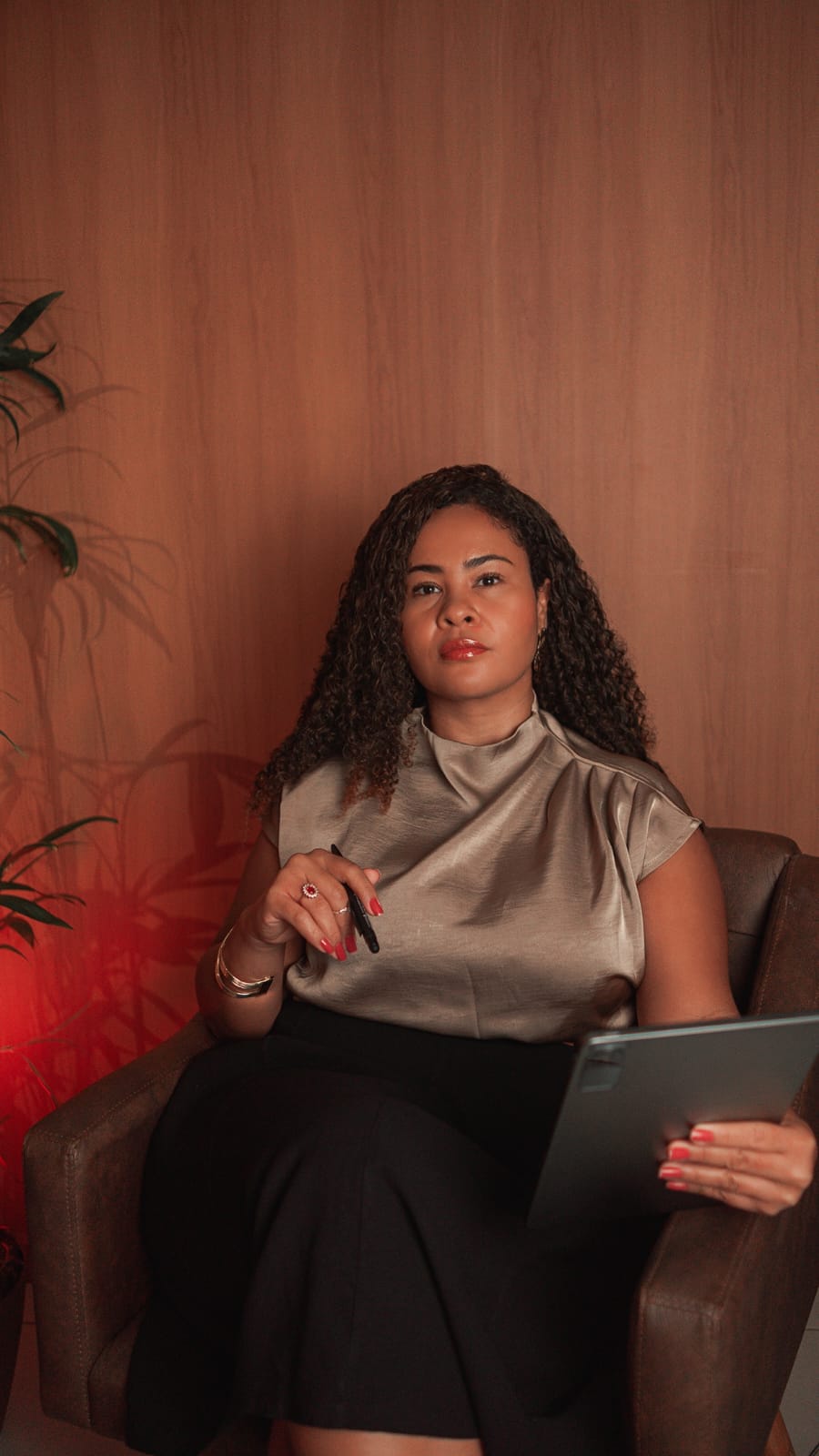 Dra. Marcela Paixão analisando documentos com tablet e caneta durante consultoria jurídica