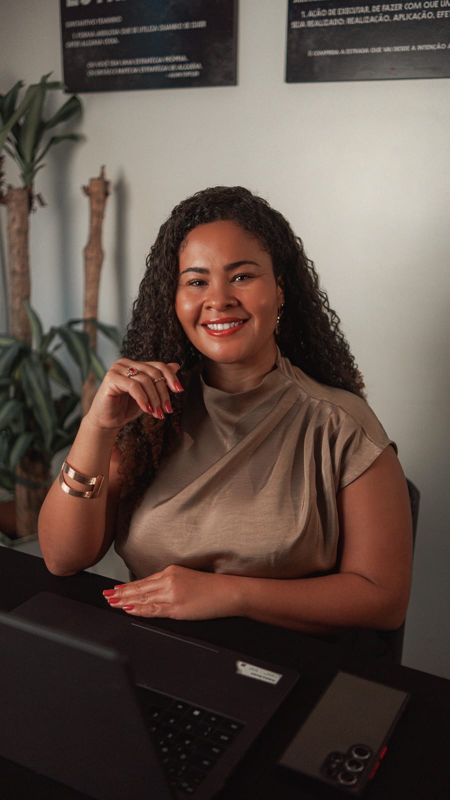 Dra. Marcela Paixão sorrindo à mesa de trabalho no escritório Paixão Lopes Advogados